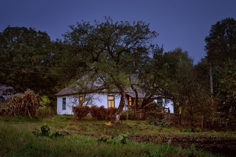 Old hut in village autumn evening scene