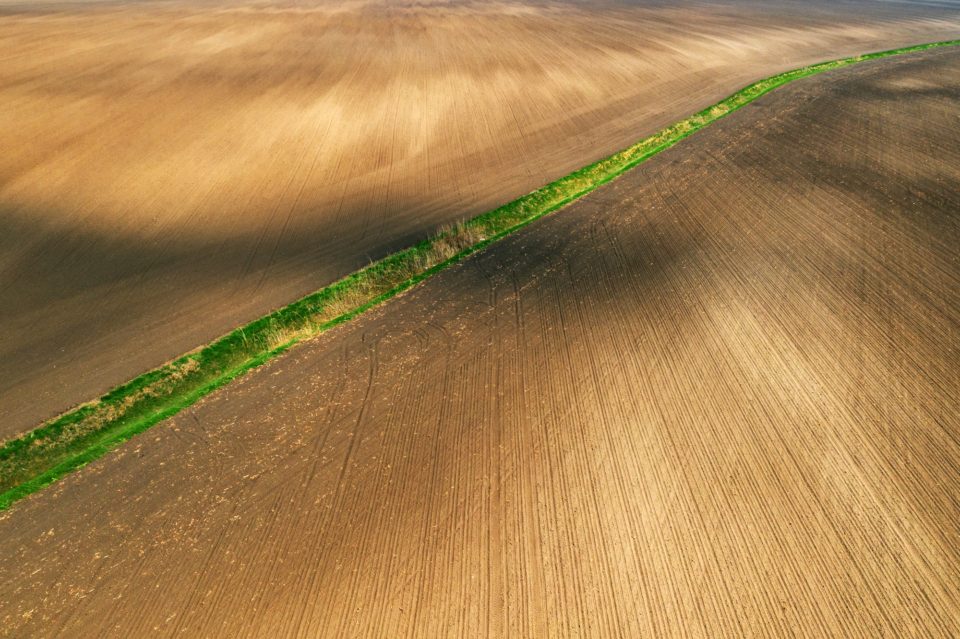 Aerial view of dried irrigation ditch canal through agricultural