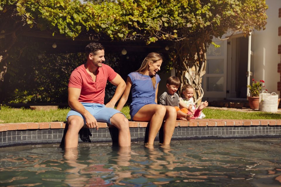 Happy young family enjoying near pool
