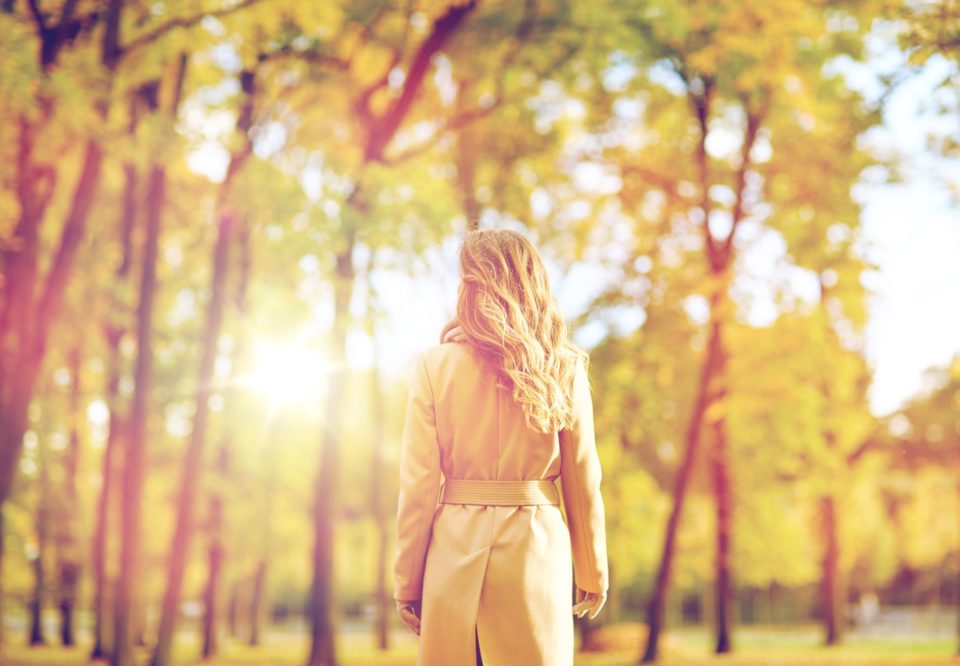 beautiful young woman walking in autumn park