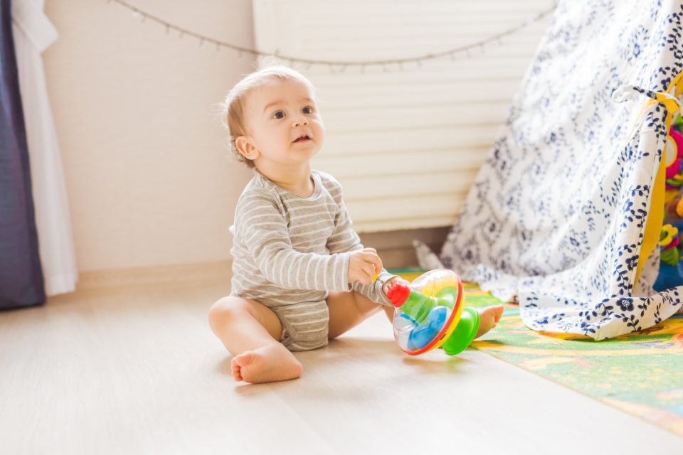Cute child boy toddler playing with toy indoors