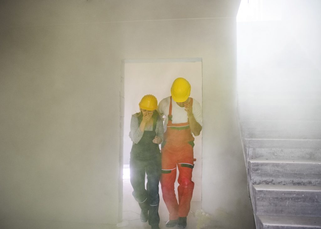 Woman and man workers suffocating at the construction site.