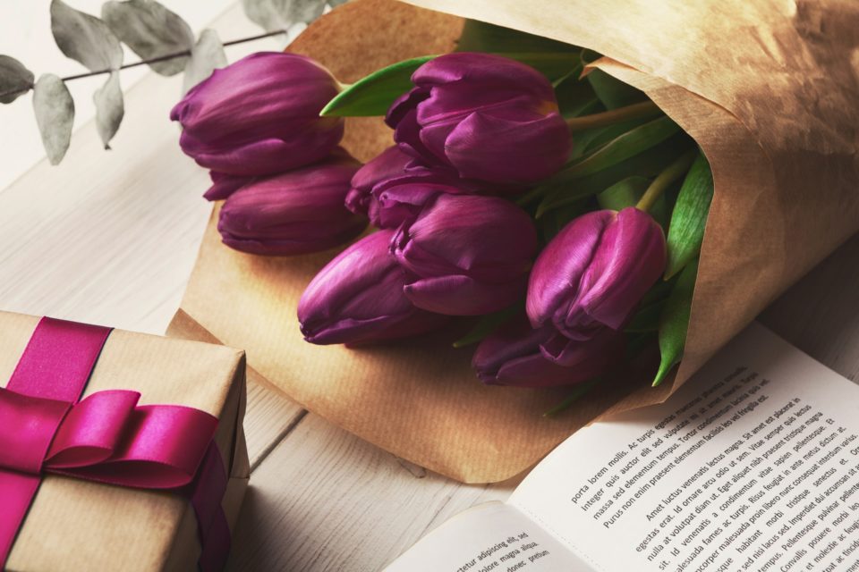 Bouqet of purple tulips and gift box on wooden background