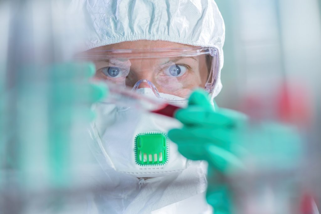 Virologist healthcare professional analyzing blood test sample in lab tubes