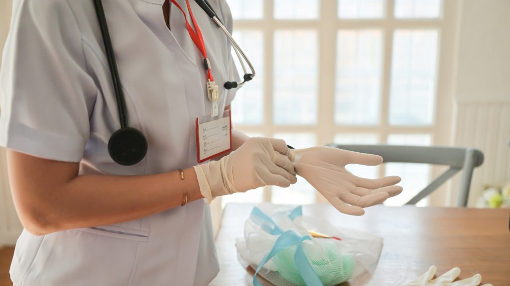 Cropped shot of Nurse is wearing gloves to protect the covid-19 while working.