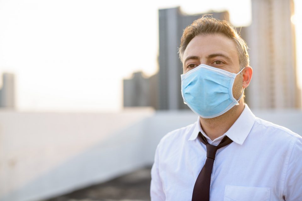 Mature businessman wearing mask for protection from corona virus outbreak and pollution