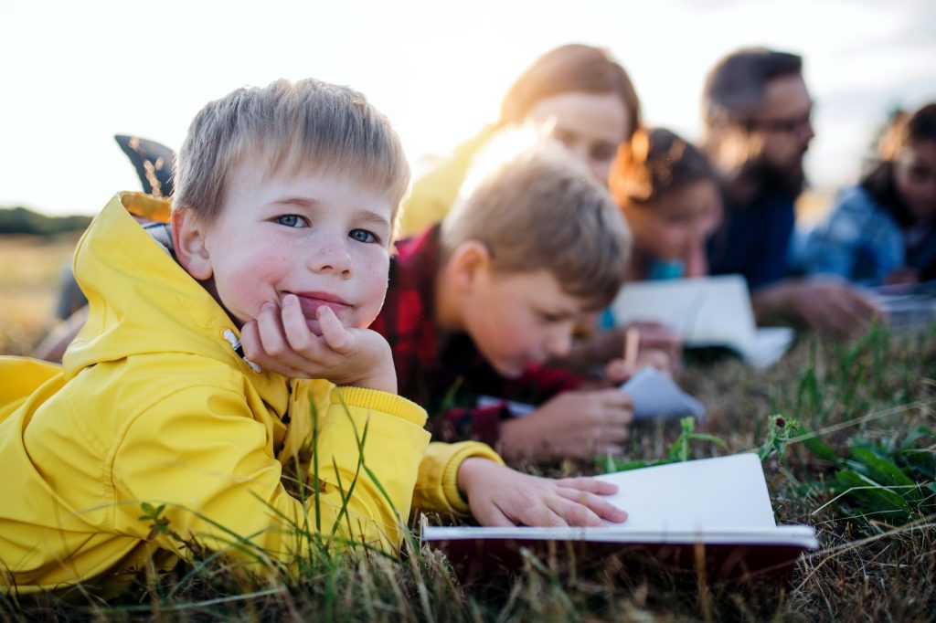 Group of school children with teacher on field trip in nature.