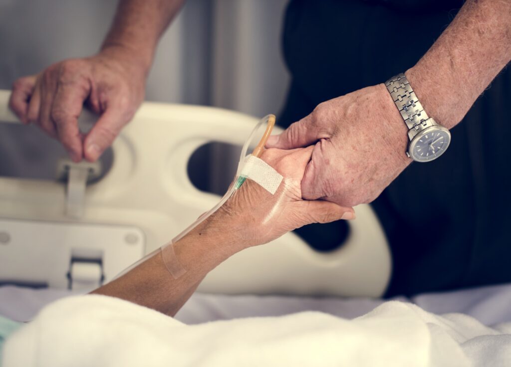 Husband holding hands of his wife in a hospital