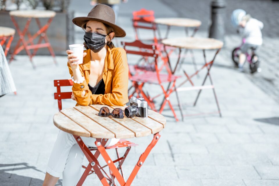 Woman in facial protective mask at the cafe outdoors