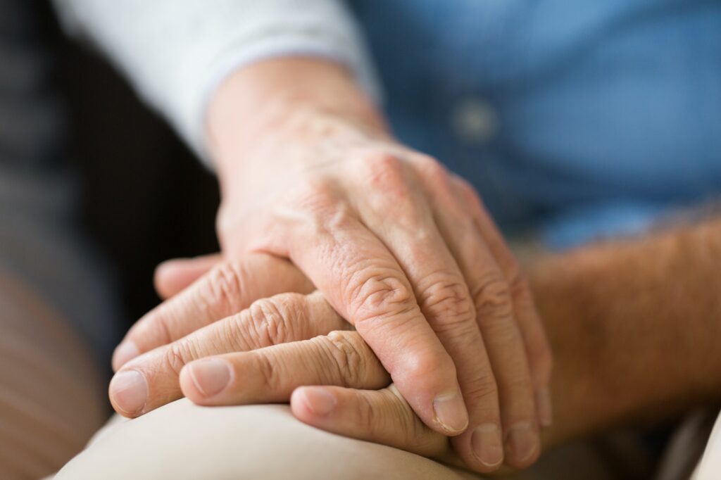 close up of senior couple holding hands