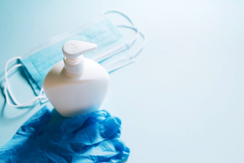 Face mask with hand sanitizer bottle, liquid soap dispenser and latex gloves. Coronavirus prevention