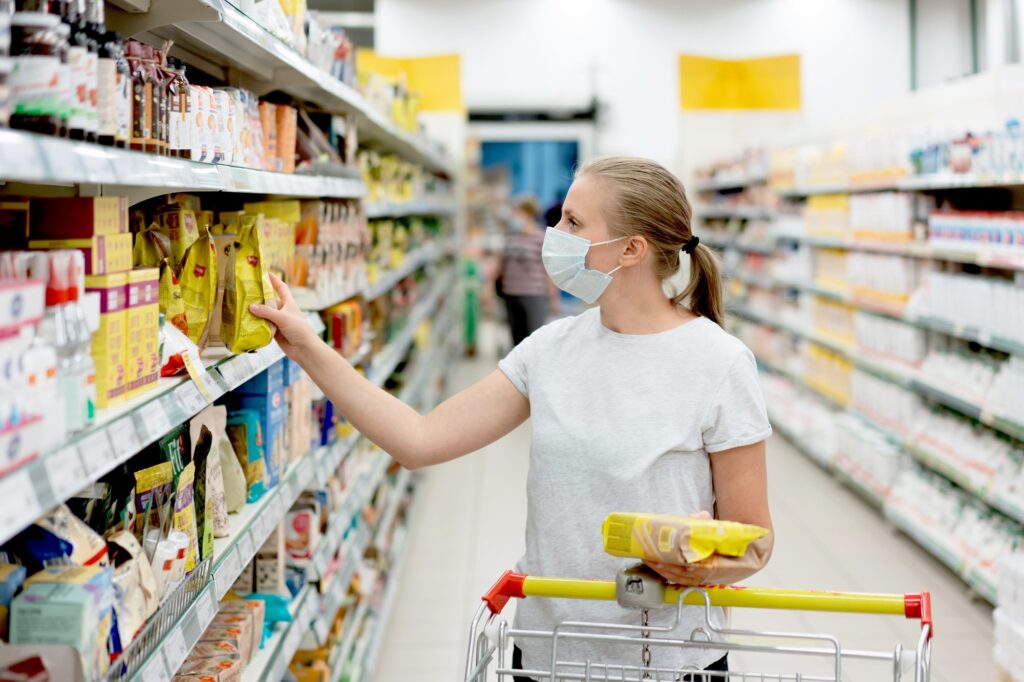 masked woman is shopping at the supermarket