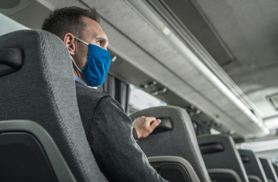 Men in Safety Breathing Mask on His Face Traveling Alone in a Bus Coach