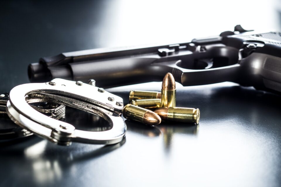 Pistol bullets, handgun and handcuffs.