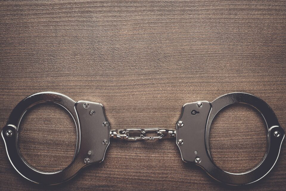 steel handcuffs on the wooden background