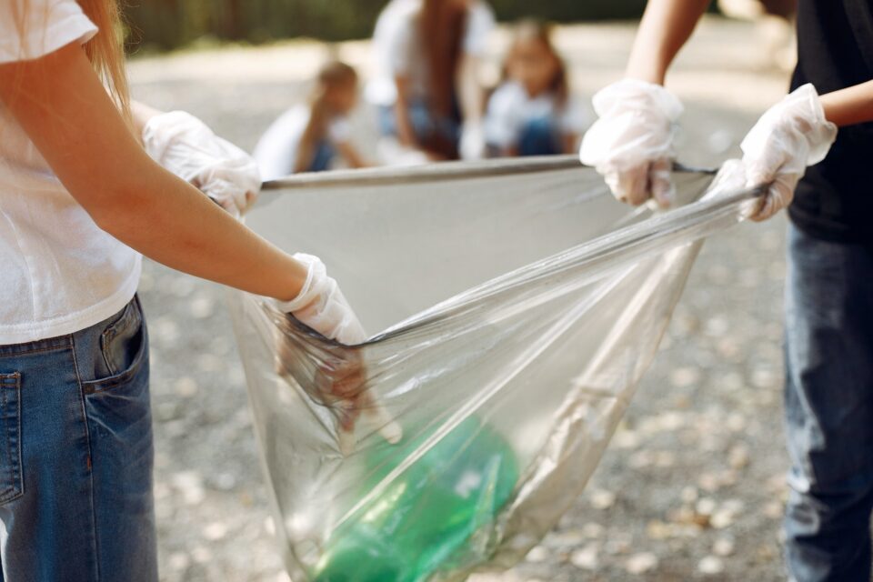 Children collects garbage in garbage bags in park