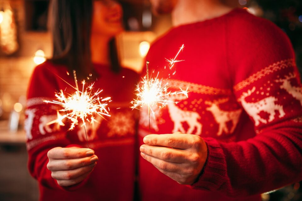 Love couple holds sparklers in hands, christmas