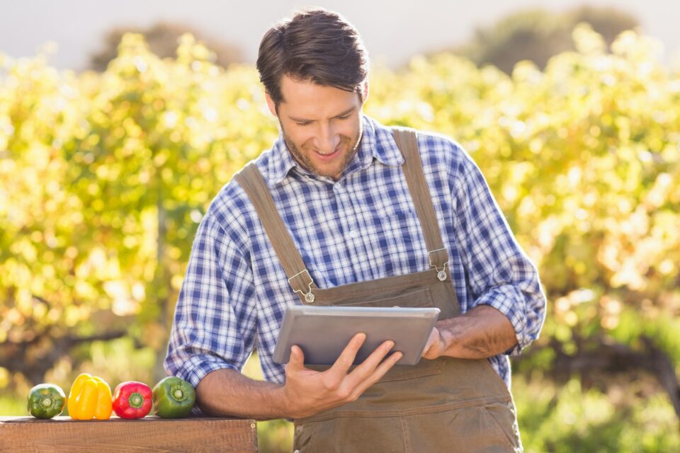 Smiling farmer using a digital tablet in the countryside