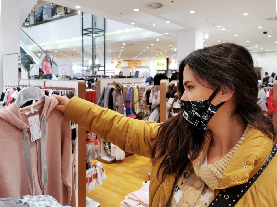 Young woman shopping for clothes. Retail shopping, mask, wearing mask, corona, covid.