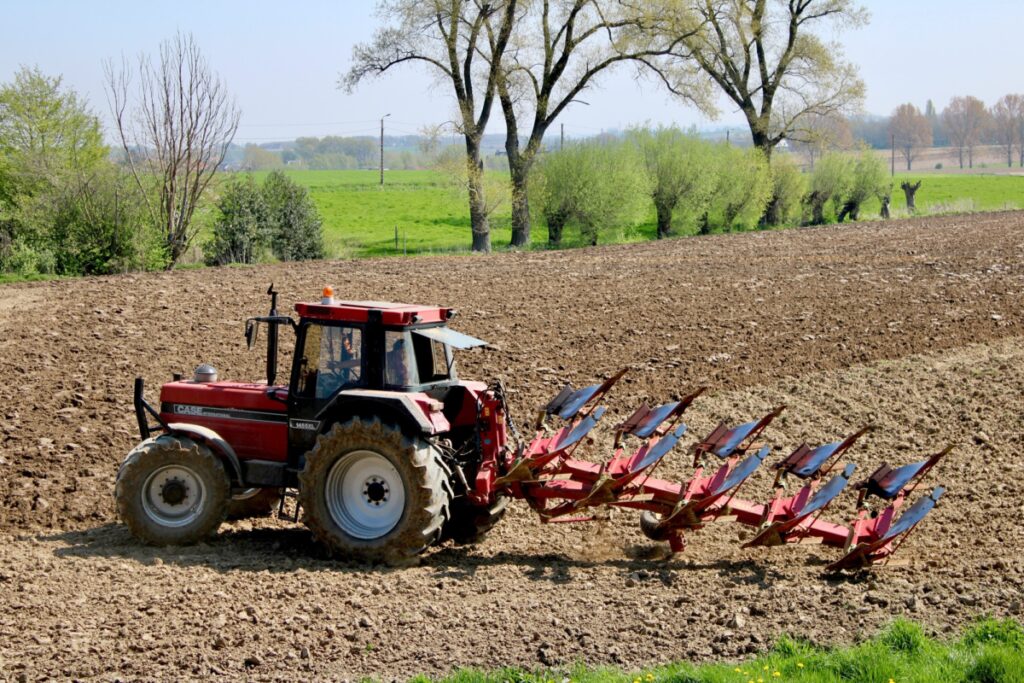 Tractor working the farmland , agriculture