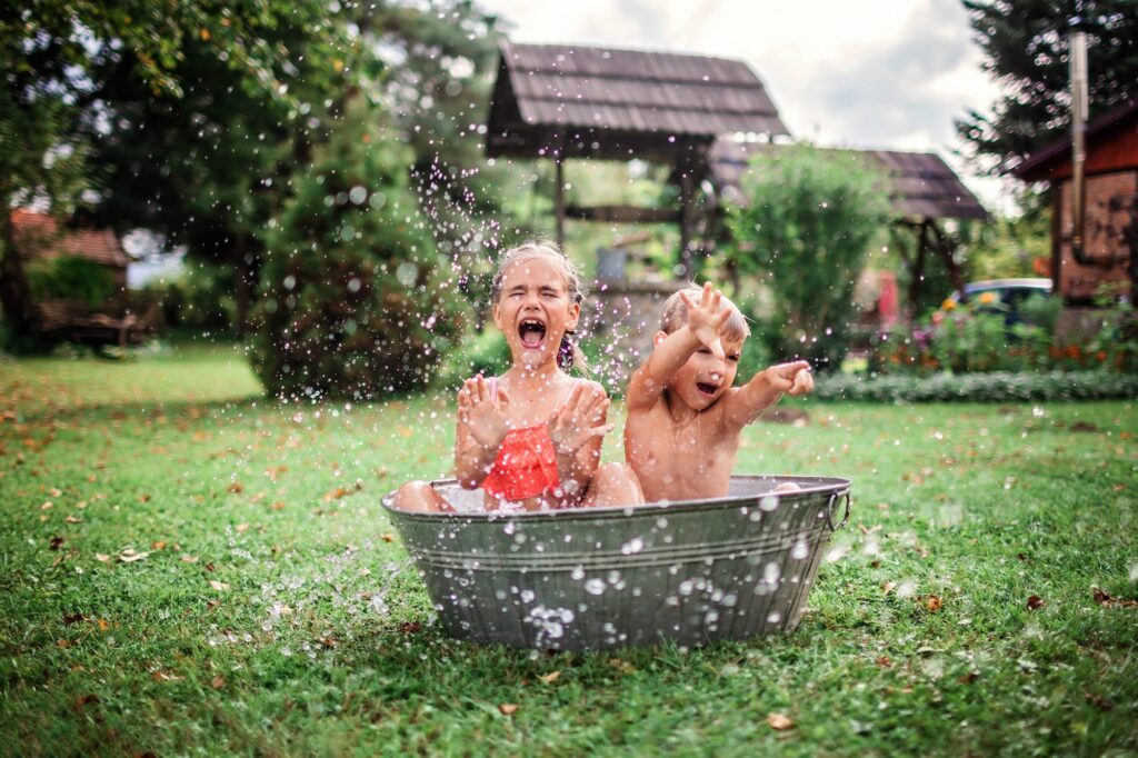Kids splashing water in the retro swimming pool, cooling in summer heat