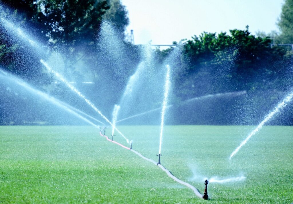Spraying water on the football field in the hot and dry summer.