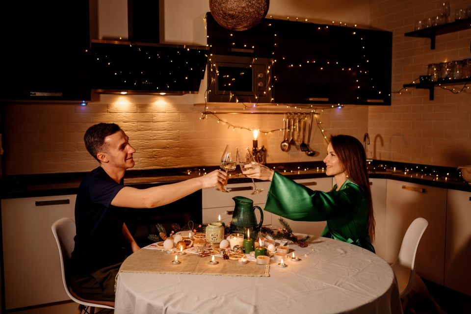 Young couple on a romantic date celebrating christmas, valentine's day and drinking sparkling wine