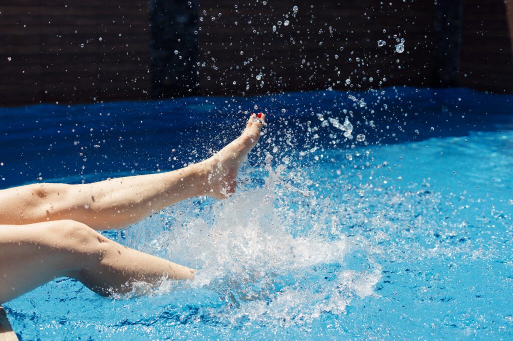 Woman splashing her feet in water on warm summer day