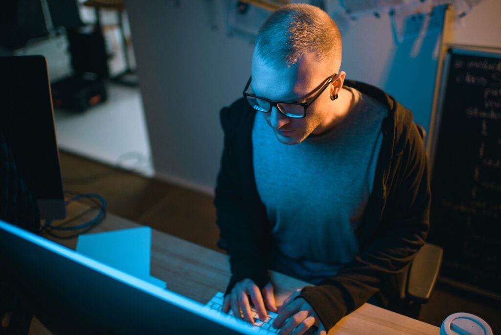 high angle view of hacker developing malware in dark room