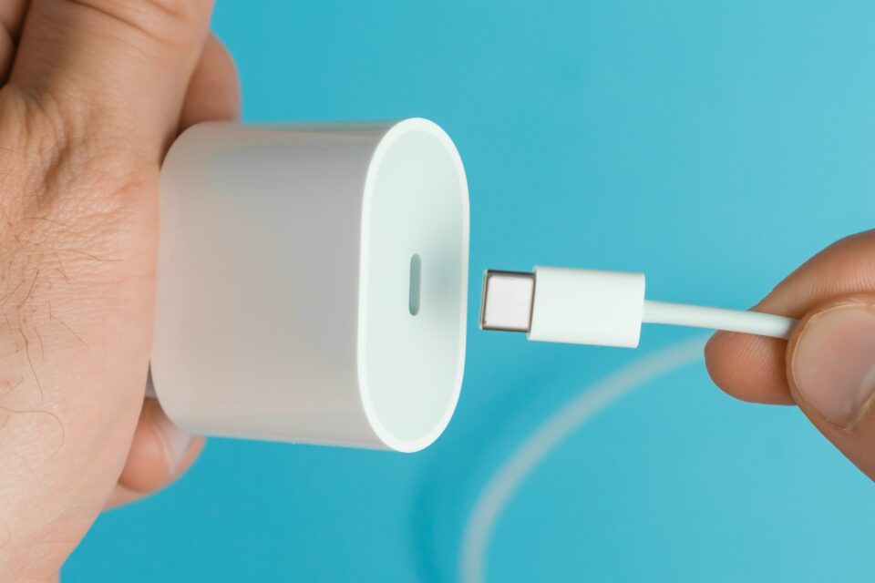 Usb type C cable inserting to adapter plug by man on the blue background
