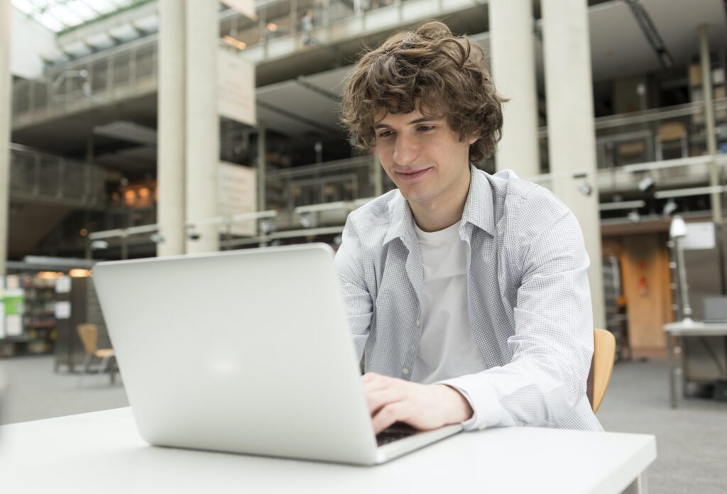 Student using laptop in a university library