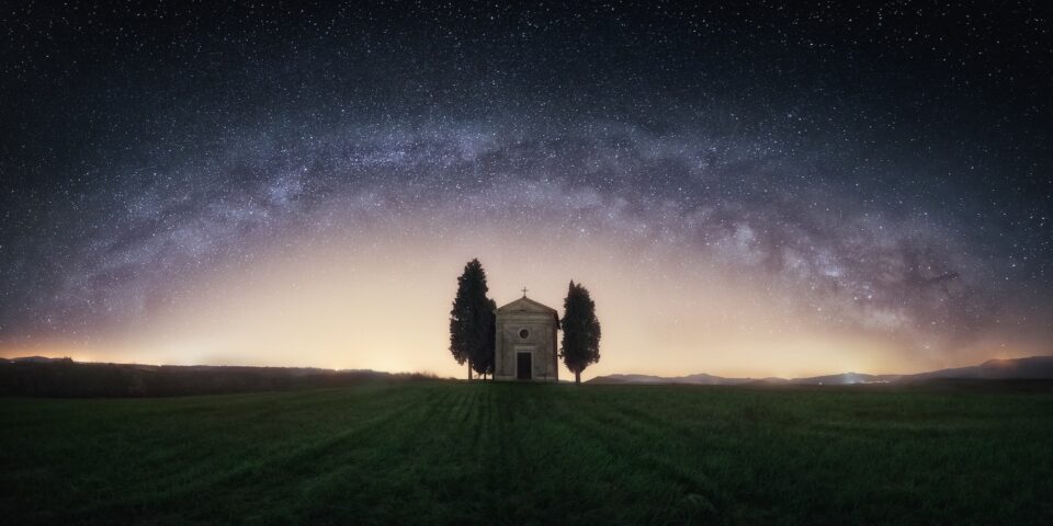 Single chapel among trees on field under stars